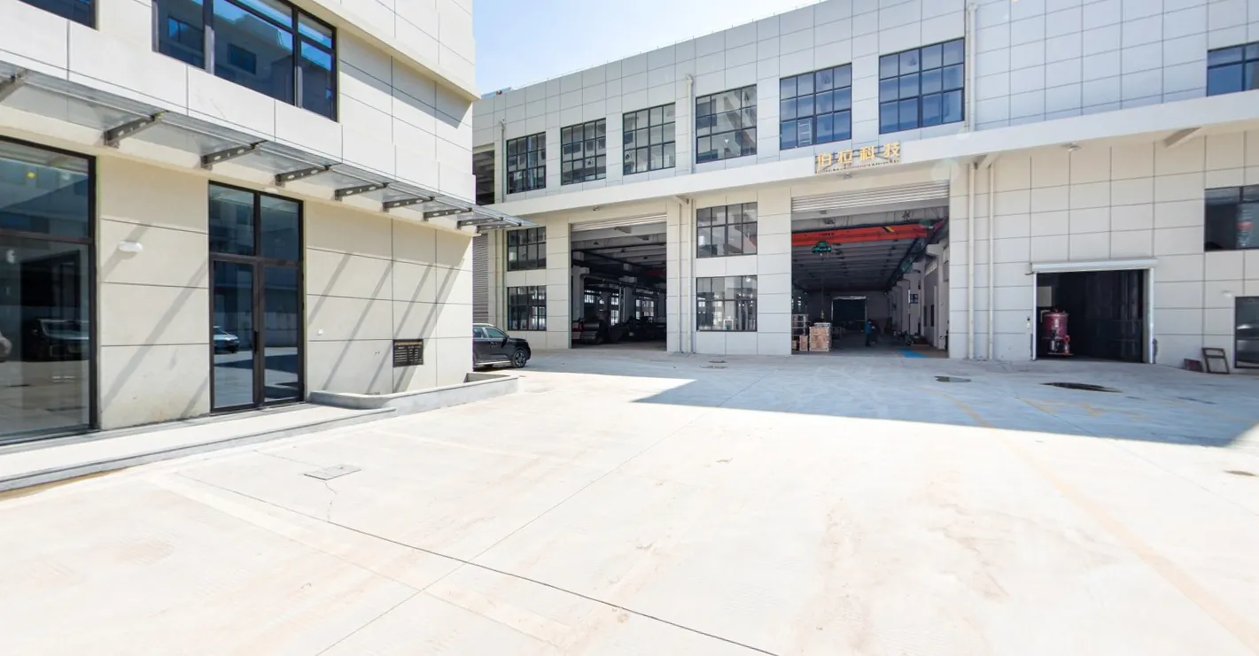 Exterior view of CannaSpring factory building and loading area. - CANNASPRING Machinery